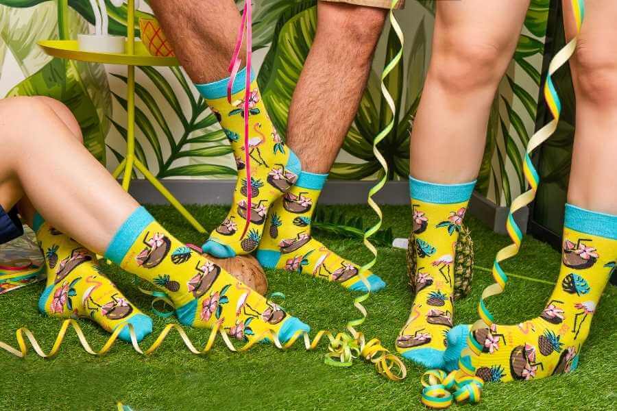 People’s legs on an artificial lawn, a party, people wearing colourful Party Socks 